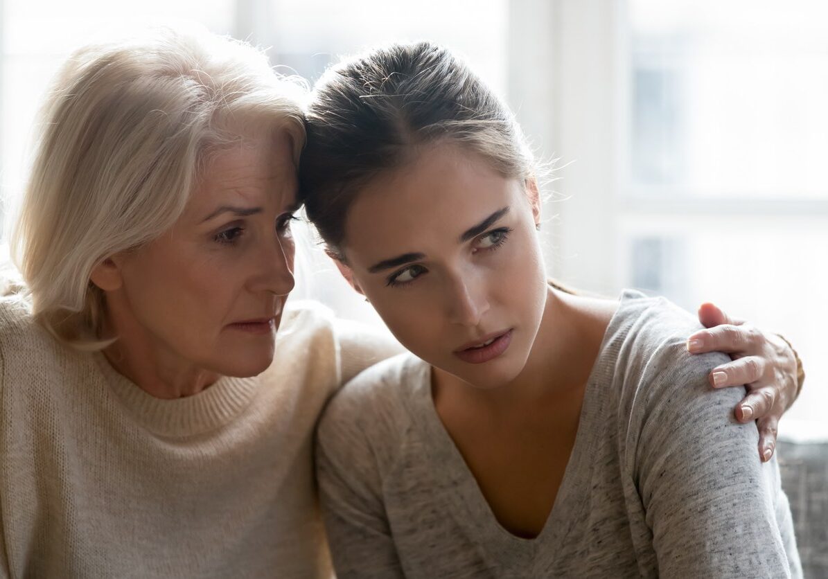 Close up of loving empathetic elderly mother or grandmother calming show sympathy to grown up daughter or granddaughter in difficult life situations break up heart break personal life problems concept