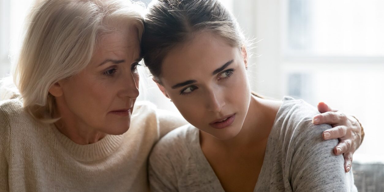 Close up of loving empathetic elderly mother or grandmother calming show sympathy to grown up daughter or granddaughter in difficult life situations break up heart break personal life problems concept