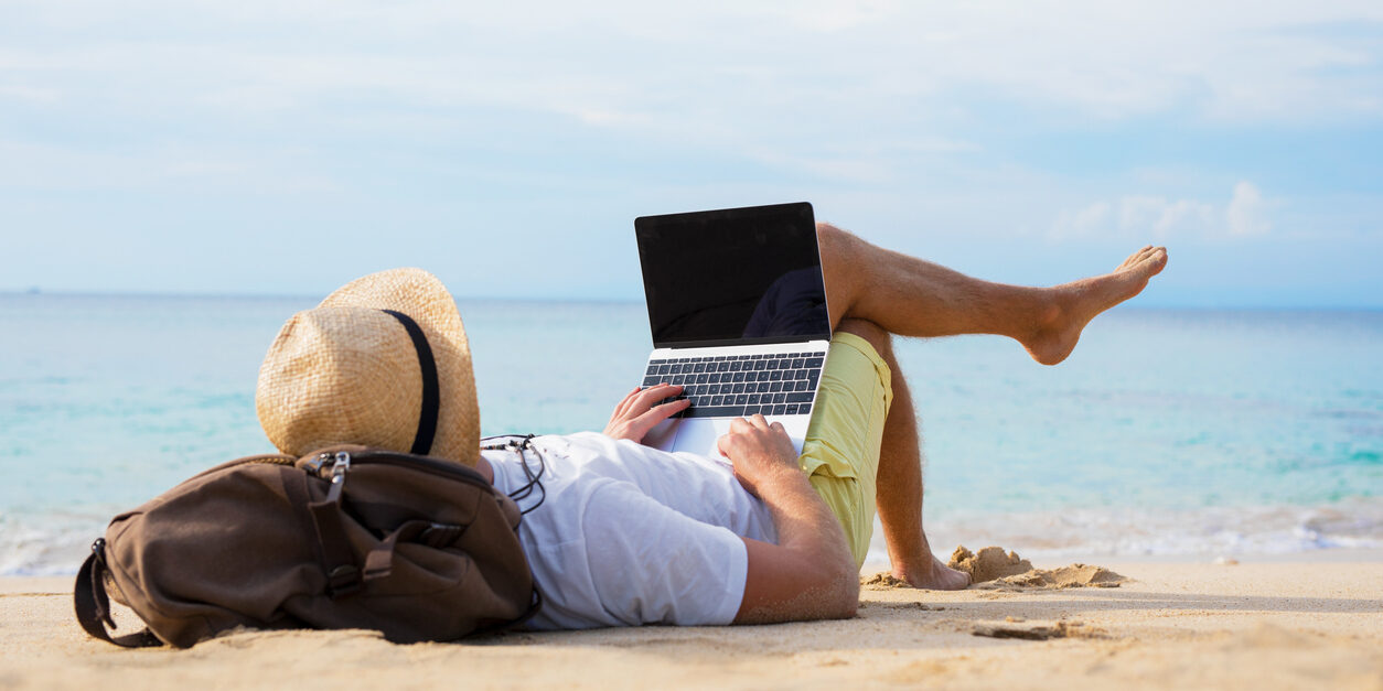 Relaxed man with laptop on the beach